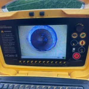 CCTV drain survey in Greater Manchester showing a monitor showing live pipe inspection footage.