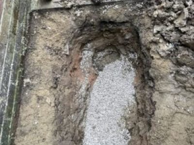 Bedding aggregate laid in trench before reinstating collapsed drain repair in Oldham