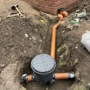 New inspection chamber connected to underground drainage pipework on a commercial installatio
