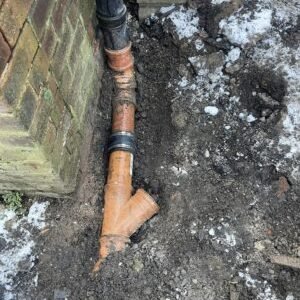 Drainage junction and downpipe connection fitted at ground level