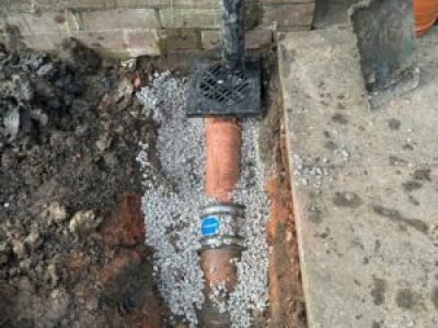 Rainwater gully connected to new pipework, ready for backfilling in Tameside