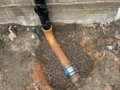 Soil pipe connected to new underground pipework as part of repair in Tameside