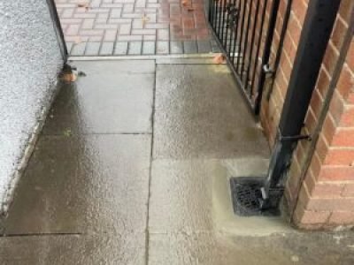 Finished gully replacement set in place at base of downpipe with paving restored in Wigan.